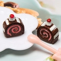 Macro shot of two miniature chocolate roll cakes with red cherry and cream detail - Coffee (Style B)
