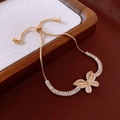 Verstellbares Goldarmband mit Kristall Schmetterling auf einem Holztablett - Verstellbares Armband mit Schmetterlingsmuster und Zirkonia / Gold