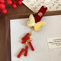 Detailaufnahme der Haarklammer aus rotem Samt mit goldenem Schmetterling und Anhängern - Wohlstand 'Fa' Charakter Schmetterling Quaste Stil