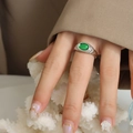 Silver ring with oval green gemstone and wavy texture on elegant model finger - Ring / Steel Green Crystal / US 6