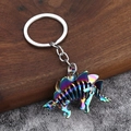Makroansicht eines farbenfrohen Stegosaurus-Dinosaurier-Skelett-Schlüsselanhängers aus Metall - Regenbogen Stegosaurus Skelett