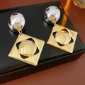Dettaglio degli orecchini geometrici bicolore oro e argento su espositore in pelle - Ago d'Argento - Argento - Oro