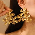 Elegant triple flower drop earrings in gold finish worn by model for stylized look - 18K Gold Flower (3436)