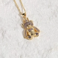 Goldene Teddybär Halskette mit Krone und violetten Zirkonia auf weißem Stein - Violetter Zirkonia