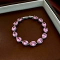 Detail van de zilveren armband met 14 roze peervormige stenen en een vouwsluiting - Waterdruppel klikarmband / Roze
