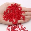 Handheld view of bright red bow-shaped resin beads for DIY hair accessory making - 60 Pieces / Red