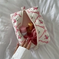 Flat lay of a white quilted floral makeup bag with pink ribbons and cosmetics on white linen - 17.5*12*10cm / Pink Bowknot