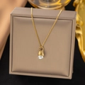 Elegant gold-plated stainless steel necklace with white pearl charm on jewelry box - Teardrop Pearl (H86) / Gold