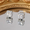 Makroaufnahme quadratischer Kristallohrstecker mit Halo-Diamanten auf einer Spiegelfläche - Silber + Klarer Zirkon