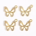 Detailed macro view of four golden alloy butterfly charms with inlaid white rhinestones - Gold Butterfly