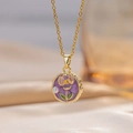 Dettaglio macro di una collana con ciondolo a fiore placcato oro con rosa smaltata viola e perla - Viola
