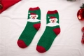Detailansicht der weichen Korallenvlies-Weihnachtssocken mit festlichem Weihnachtsmann-Motiv - Einheitsgröße / Grün Weihnachtsmann