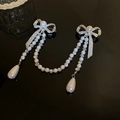 Detail of silver bow brooch with rhinestone inlay and pearl tassel on black background - Silver Bowknot Tassel