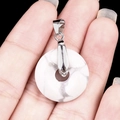 White turquoise donut pendant with marble texture and silver clasp held in hand - 20mm Howlite White Turquoise