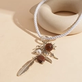 Detalle de collar bohemio con plumas de metal, cuentas de madera y dijes de perlas - Collar-Pluma Marrón