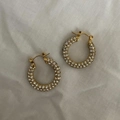 Macro detail of 25mm gold hoop earrings with sparkling pave-set cubic zirconia stones - White