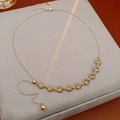 Detail van verstelbare gouden ketting met elf gele kristallen op grijs fluwelen kussen - Koffiegoud-Groen