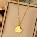 Dettaglio macro del ciondolo a cuore dorato con trama a nido d'ape e incisione Forever - Cuore a Griglia Forever