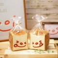 Two toasted bread loaves in greaseproof white paper bags with clear windows and smileys - Squinting Pattern / 19x29+4cm