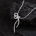 Collier élégant avec pendentif en forme de ruban argenté et chaîne serpent sur fond noir - Argenté
