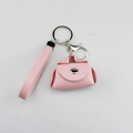 Gedetailleerd close-up van een roze PU-leren mini-portemonnee sleutelhanger met polsbandje - Roze