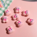 Flat lay of eight cute pink resin bunny beads with bows for DIY jewelry making - Pink Rabbit (1 Piece)