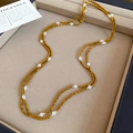 Dettaglio della collana di perline dorate sfaccettate e perle bianche su velluto - Collana-Caffè-Perla