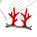Par de horquillas de asta de reno rojas para niños sobre fondo de libro - Cuernos de Reno Rojos