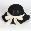 Detailed texture of black woven sun hat with elegant beige lace bow decoration - Black