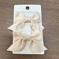 Set aus zwei cremefarbenen Ripsband-Haarspangen mit Schleife auf weißer Karte - Beige