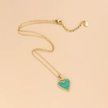 Collar de corazón dorado con incrustación de textura malaquita verde en fondo beige - Malaquita Verde