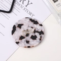 Detail of round tortoiseshell acetate compact mirror with gold Barrette La France text - Black & White Marble
