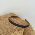 Close-up of navy blue matte fabric headband placed on a straw hat with a white background - Dark Gray