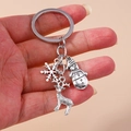Détail d'un porte-clés de Noël argenté avec flocons de neige et pendentifs renne - Flocon de Neige/Bonhomme de Neige/Élan