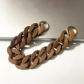 Macro detail of brown matte acrylic chain strap with gold round spring buckles - Brown