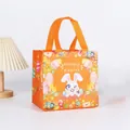 Orange non-woven Easter gift bag featuring cartoon bunnies, eggs, and Happy Easter text - XH20-Horizontal