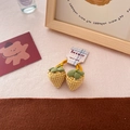 Detail of yellow plaid strawberry hair ties with green leaves and fabric textures - Yellow