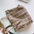 Nahaufnahme der Vintage-Canvas-Tasche mit Karomuster und Baumwollgriffen auf Holz - Gelb Kaffee Kariert