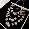 Gros plan du collier triple rang en métal avec disques martelés sur velours noir - Argent (Ensemble de 3 pièces)
