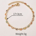 Detail view of gold flower bracelet with colorful heart enamel charms and extension chain - Moon Bracelet