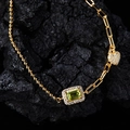 Macro shot of s925 silver bracelet with emerald cut green gem and heart charm - Gold Plated Natural Peridot