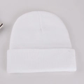 Detailed close-up of pure white knitted beanie showing soft fabric texture and ribbed cuff - Adult 56-60cm / White