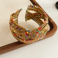 Detail van een bohemian meerlaagse glaskralen armband op een houten dienblad display - Kleurrijk