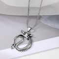 Detail van een vintage zilveren draakhanger met fijne schubben aan een kogelketting - Stijl 8: Ronde Draak