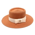Detailed close-up of a caramel straw boater hat with beige ribbon and golden bee ornament - M (56-58cm) / Caramel
