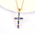 Detail van de kruishanger met rechthoekige blauwe zirkoon op gouden O-ketting - Donkerblauw