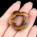 Handheld view of a 30mm natural tiger eye stone pendant in a carved flower design - Tiger's Eye