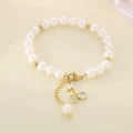 Detail of beaded pearl bracelet featuring sparkling cherry pendant and gold lobster clasp - Zirconia Clear Cherry Style (KB203076-Z)