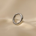 Bague ouverte argentée irrégulière et ovale évidée sur un tissu en soie beige - Argenté