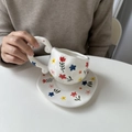 Hand-painted ceramic coffee cup and saucer with colorful floral patterns and irregular shape - White with Large Floral Cup & Saucer Set / Cup + Saucer Set